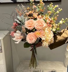 a bouquet of flowers sitting on top of a white table next to a dresser and mirror