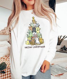 "Christmas Tree Shirt, Christmas Cat Shirt, Meowy Christmas Shirt, Christmas Cat Shirt, Retro Christmas Shirt, Merry Christmas Shirt 2023  Hi! Welcome to ThamDessignLTD.  We're thrilled to have you here!  At ThamDessignLTD, we offer a range of clean, high-quality, and soft shirts. Each item is carefully prepared by our boutique and undergoes thorough ironing before being shipped to you. We want you to have a seamless shopping experience and enjoy browsing through our collection. If you have any questions or need assistance, please don't hesitate to reach out to us. We're here to help you at any time. To ensure the perfect fit, we kindly request you to check our size cards before making your purchase. It will help you find the right size and ensure that you're completely satisfied with your Christmas Long Sleeve Tops With Cartoon Print, Winter Cotton Top With Cat Print, White Cat Print Top For Winter, White Long Sleeve Top With Cat Design, White Cat Design Top For Winter, White Winter Top With Cat Design, White Christmas Tops With Cartoon Print, White Christmas Cartoon Print Tops, White Tops With Cartoon Print For Christmas