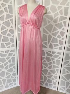 This is a sweet v neck sleeveless satin nylon nightgown with a plaited tie under the bust and ties at the back. It is new old stock with tags by Jillray made in Australia in the 60s or 70s. It is a long below knee length  Condition is very good  Bust 96cm Length shoulder to hem 142cm Spring Sleeveless Satin Nightgown, Sleeveless Satin Nightgown For Spring, Summer Satin V-neck Nightgown, Spring Evening V-neck Nightgown, V-neck Spring Sleepwear, V-neck Evening Sleepwear For Spring, Spring Evening V-neck Sleepwear, Feminine V-neck Party Nightgown, Sleeveless Satin Nightgown For Summer