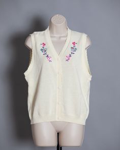 Cute womens 70s 80s button front knit vest. Cream color with pretty flower and butterfly design. S.G. SPORT Collection size - Medium vintage pre-owned Retro V-neck Vest For Spring, Retro Cotton Sweater Vest For Spring, Vintage V-neck Vest For Spring, Retro V-neck Spring Vest, Spring V-neck Retro Vest, Vintage V-neck Sweater Vest For Spring, Retro Spring Vest, Vintage Sleeveless Sweater Vest For Spring, Spring Vintage Vest