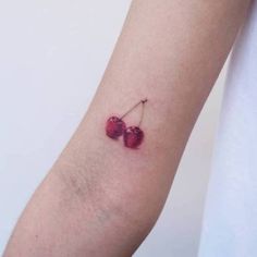 two cherries tattoo on the left arm