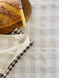 a loaf of bread sitting on top of a wooden cutting board next to a knife