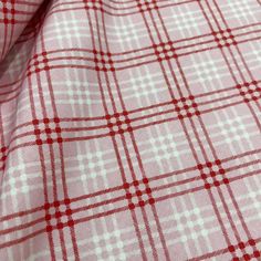 a red and white checkered fabric is shown in close up view on the surface