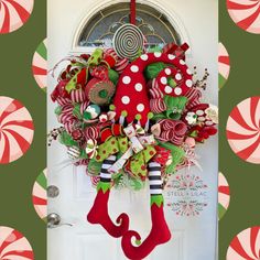 a christmas wreath hanging on the front door with candy canes and stocking around it