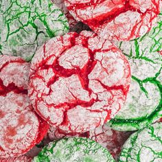 red and green cookies are covered in powdered sugar on top of eachother