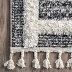 an area rug with tassels on top of it