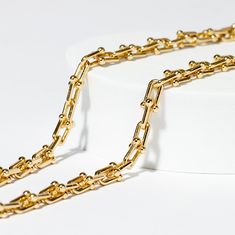 Your go-to accessory for effortless style and modern glamour! This piece is composed of multiple horseshoe shaped 1cm links with small gold balls as clasps, making it an instant standout. Tiffany's sell their solid gold version for $25,000! Our necklace offers the same chic look and with waterproof. tarnish proof, 18K Gold coating for a fraction of the cost but with all the same life-proof durability. All our pieces come with free extenders attached so you can fit the look to your own body and s Gold Chain Link Necklace For Everyday Luxury, Gold Paperclip Chain Necklace For Everyday Luxury, Classic Gold Chain Necklace With Hooks And Links, Luxury Gold Chain Necklace With Paperclip Design, Luxury Yellow Gold Chain Necklace With Hook And Links, Classic Chic, Simple Elegance, Body Style, Chic Design