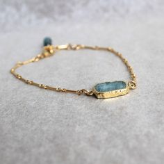 "Subtle shades of tropical waters in pale blue and bright gold,  These rough slices of aquamarine are dipped in gold plate.  Bracelet chain and  clasp are all gold filled.  A delicate gold-filled wrapped aquamarine stone finishes the bracelet.  Adjustable size 7\"-8\" The earrings can be purchase separately at https://www.etsy.com/listing/1163103992/rough-cut-aquamarine-with-gold-dangles?click_key=a8a3c24b59a65ea05319c8bce692c0718c5b2a90%3A1163103992&click_sum=b772d68a&ref=shop_home_active_5&frs Lucky Stone, Aquamarine Jewelry, Bracelet Chain, March Birthstone, Aquamarine Stone, Bright Gold, Gorgeous Bracelet, Training Center, Dream Jewelry