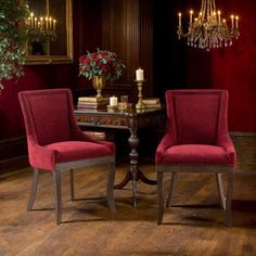 two red chairs sitting in front of a table