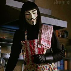 a person wearing a mask and apron in a kitchen