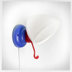 a red, white and blue phone is hanging on the wall with a hook attached to it