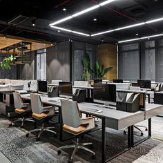 an empty office with desks, chairs and plants in the middle of the room