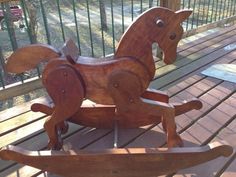 a wooden rocking horse sitting on top of a wooden deck