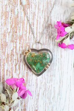 This handmade necklace features a speckled green Australian Variscite heart-shaped gemstone. Australian variscite is a rare and beautiful gemstone known for its vibrant green color and unique patterns. This large natural stone is set in sterling silver and is accented by six 18 karat gold beads. The pendant height is 1 7/8" and the width is 1 3/8" and it is attached to a 16" sterling silver chain. * Handmade in Austin, Texas. * One-of-a-kind. * Arrives in a quality Cara Carter Jewelry box that is perfect for gifting. * Ships for free (US orders only) within 1-2 business days. Carter Jewelry, Sunset Valley, Gold Heart Necklace, Vibrant Green, Handmade Necklace, Gold Heart, Austin Texas, Heart Of Gold, Sterling Silver Chain