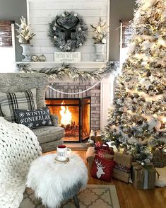 a living room decorated for christmas with a fireplace and tree in the corner, stockings on the mantel