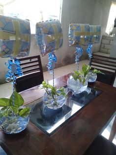 three vases filled with plants on top of a wooden table