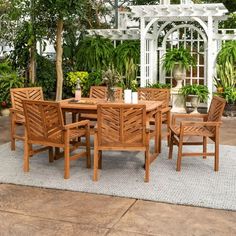 a wooden table and chairs sitting on top of a rug in front of a gazebo