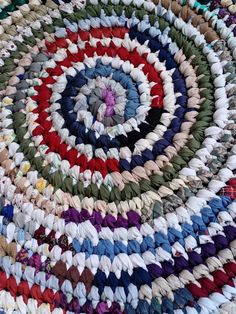 a multicolored round rug made out of various colored yarns on top of each other