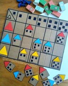 an image of a board game with blocks and houses on it, next to scissors