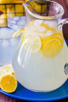 a pitcher filled with lemonade sitting on top of a blue plate