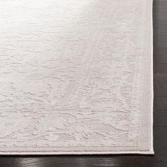 a large white rug on top of a wooden floor