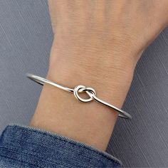 This simple knot bangle is a symbol of enduring connections and timeless elegance. The bangle features a beautifully crafted knot design, symbolizing unity and strength in a sleek and polished sterling silver finish. 925 Sterling silver High polish finish Approx. 2.6" inner diameter Handmade in Taxco, Mexico Elegant Sterling Silver Bracelet For Friendship, Modern Twist Bangle As Gift, Knot Bangle, Knot Design, Sterling Silver Bangle, Silver Bangle Bracelets, Love Knot, Sterling Silver Bangles, Silver Bangle