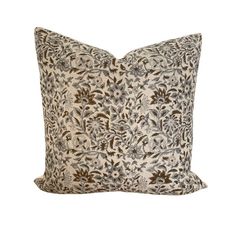 a brown and white floral pillow on a white background with a black flowered design