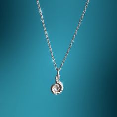 Ammonites once ruled the seas with prehistoric nautical dinosaurs, their swirling shell swimming among some of the largest sea creatures in recorded history. Perfect for gifting, this sterling silver fossil pendant is the ideal gift for those who love the water and Natural History. Your pendant will arrive wrapped in tissue paper and presented in a faux suade jewellery pouch - 925 silver ammonite  charm - Ammonite measures approximately 12mm - Suspended from a 18 inch 925 Sterling silver chain w Fossil Necklace, Ammonite Wire Wrap, Unique Silver Shell-shaped Necklace, Opalized Ammonite, Ammonite Necklace, Ammonite Earrings, Ammonite Jewelry, Victorian Pendants, Spiral Design