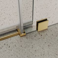 a close up of a glass door with a gold handle on the bottom and side