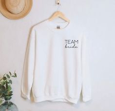 Team Bride Sweatshirts 🕊️🤍✨ Team Bride Sweatshirt, White Crew Neck Top For Bridesmaids, White Crew Neck Top For Bridal Shower, Cotton Crew Neck T-shirt For Hen Party, Bride Items, Bride Sweatshirt, Sweat Shirts, Bride Tribe, Team Bride