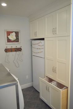 a kitchen with white cupboards and drawers in it's center area, next to an oven