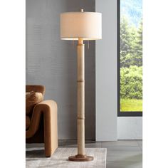 a lamp that is on top of a table next to a couch in a room