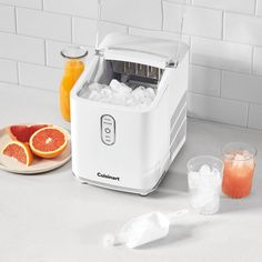 a white toaster sitting on top of a counter next to oranges and ice