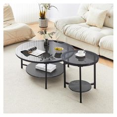 two black tables sitting on top of a carpeted floor next to a white couch