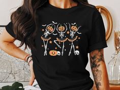 This fun Halloween T-Shirt features a playful design of skeletons dancing with pumpkin heads, stars, and ballet elements. Perfect for adding a spooky yet cute touch to your Halloween wardrobe, this shirt is great for costume parties, casual wear, or gifting to friends and family who love the Halloween spirit. Wear it to show your festive side and enjoy the compliments on your unique style. Thank you for choosing Cozy Cupfuls! We're so excited to have you here and truly appreciate your support. Our shop is all about offering you high-quality, cozy, and stylish products that you'll love. We believe in providing a warm and welcoming shopping experience, and we're always here to help if you have any questions or concerns. Here's a bit about what we offer: Bella Canvas 3001 Unisex T-Shirts: Cra Cute Halloween Pumpkins, Skeletons Dancing, Pumpkin Heads, Skeleton Pumpkin, Costume Parties, Halloween Geist, Skeleton Shirt, Spirit Wear, Halloween T Shirt