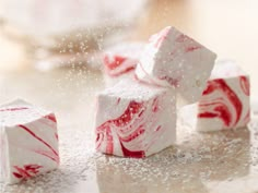 red and white swirled marshmallows sitting on top of a counter next to some sugar