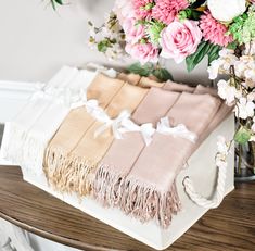 a bouquet of flowers sitting on top of a wooden table next to towels and blankets