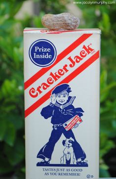 a carton of cracker jack sitting on top of a table next to some plants