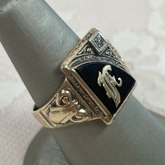 This large ring features an ornate, gold letter F centered in the onyx. A .015ct diamond is set in the corner of the ring face. This ring is covered in ornate gold details, including the face, the shoulders and around the top of the ring. The head of the ring is a substantial 13 x 16.4mm and the shank is 3.6mm wide. Size 8. We can resize rings for a fee, so please inquire! Initial F, The Ring Face, Signet Ring Men, Gold Letter, Ring With Diamond, Letter F, Large Ring, Onyx Ring, Gold Letters