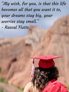 a woman wearing a graduation cap and gown looking at the mountains with her back to the camera