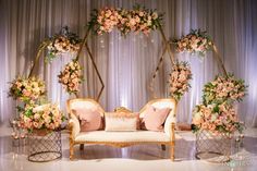 a couch with pillows and flowers on it sitting in front of a stage set up