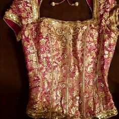 the back of a blouse with gold and pink sequins on it's shoulders