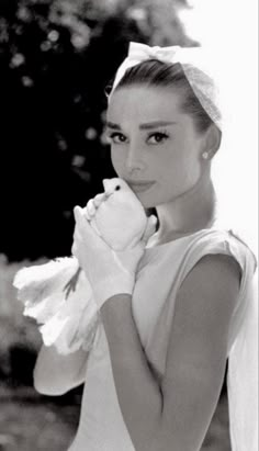 a woman in white dress holding a stuffed animal