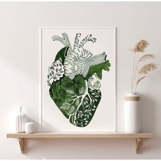 a green and white heart print on a shelf next to a vase with some flowers