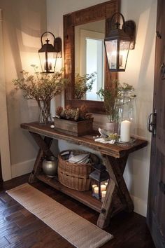 a wooden table topped with vases filled with flowers and candles next to a mirror