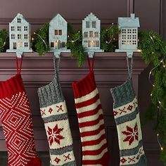 christmas stockings hanging from a mantel with houses on them