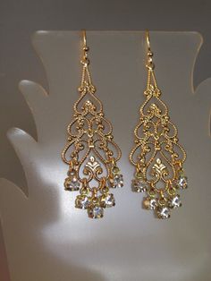 "Swarovski Crystal Filigree Earring Swarovski Crystal rhinestone filigree earrings. These stunning earrings feature large gold plated filigree with Swarovski Crystal rhinestone dangles. Earrings approximate length of 2 1/2\" from top of goldplated earwires and a width of 3/4\" across widest part. Arrives gift boxed. If you are looking for lightweight earrings that make a big statement, these earrings are for you! Perfect for the bride, bridesmaids, or that special occasion - an elegant and timel Bride Earring, Big Earrings Gold, October Jewelry, Faberge Jewelry, Gold Filigree Earrings, Bride Earrings, Crystal Dangle Earrings, Earring Gold, Filigree Earrings