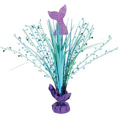 a purple vase filled with lots of blue flowers and green stems on top of a white table