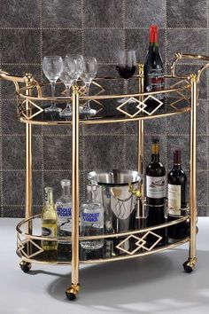 a gold bar cart with wine glasses and bottles