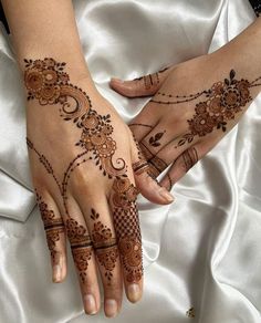 two hands with henna tattoos on them